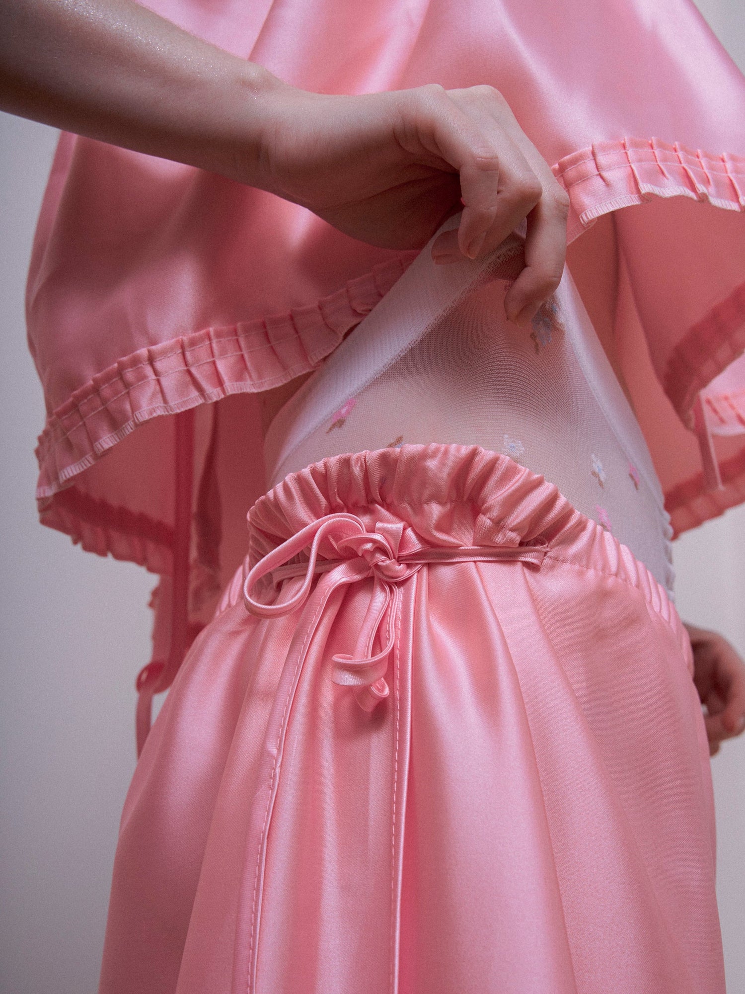 Person wearing a pink outfit with a matching skirt and top.